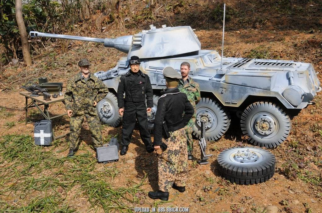 Miniature soldiers gathered around the EAXTOYS 1/6 scale WWII German Sd.Kfz.234/2 Puma model, engaged in a discussion.