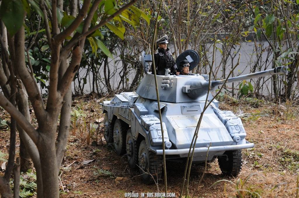 Miniature soldiers inside the EAXTOYS 1/6 scale WWII German Sd.Kfz.234/2 Puma model, peering out from the turret hatch.