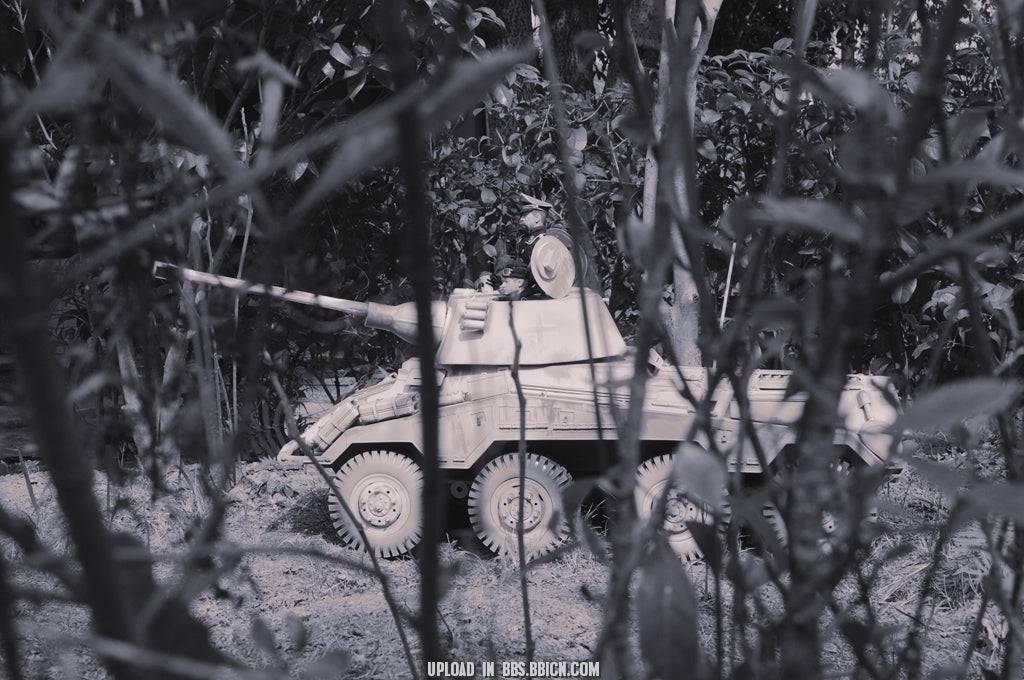 Black and white image of the EAXTOYS 1/6 scale WWII German Sd.Kfz.234/2 Puma model positioned in a forest setting.