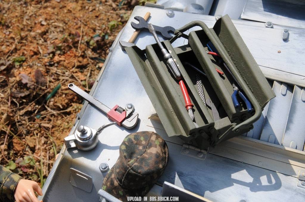 Close-up of a miniature toolset placed on the EAXTOYS 1/6 scale WWII German Sd.Kfz.234/2 Puma model, featuring wrenches and accessories.