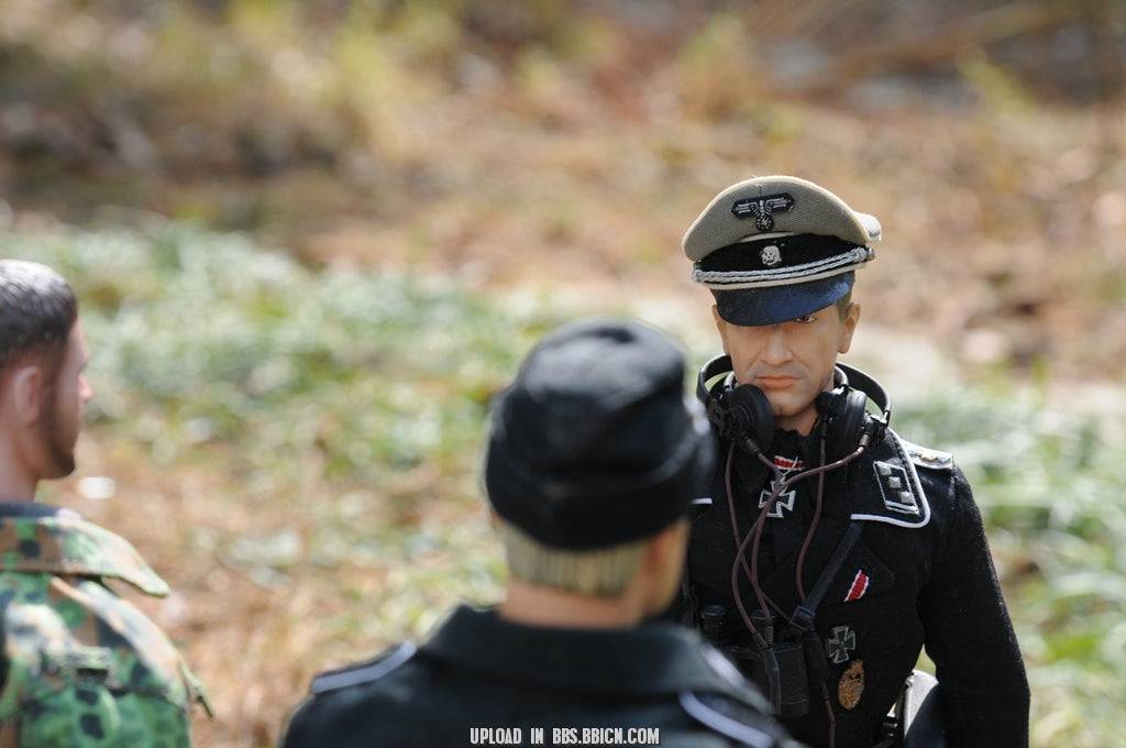 Miniature officer in black uniform with headset standing in front of the EAXTOYS 1/6 scale WWII German Sd.Kfz.234/2 Puma model.